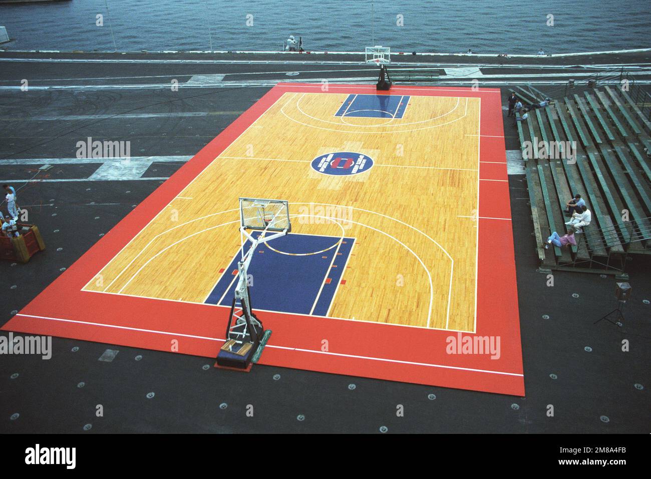 Una visione del campo di pallacanestro di regolamento istituito sul ponte di volo della portaerei USS RANGER (CV-61) per un gioco di mostra delle stelle di San Diego. All'evento hanno partecipato membri dell'equipaggio e famiglie delle compagnie aeree USS CONSTELLATION (CV-64), USS ENTERPRISE (CVN-65) e hanno invitato ospiti del San Diego Naval Training Center (NTC). Il gioco è stato sponsorizzato dalla San Diego Sports Arena in collaborazione con ESPN Sports network. Base: San Diego Stato: California (CA) Paese: Stati Uniti d'America (USA) Foto Stock