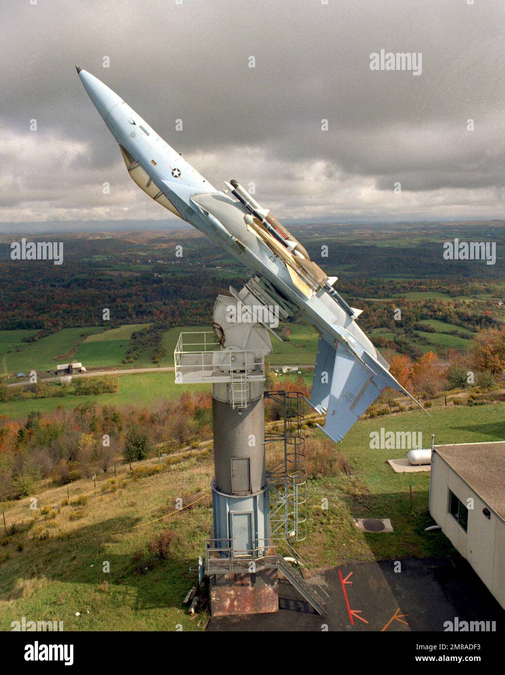 Vista laterale destra di un aereo F-15C Eagle montato capovolto su un piedistallo presso il sito di test di Newport del Rome Air Development Center. È in corso la valutazione di un pod del sistema di allarme radar montato sulla fusoliera rispetto al sistema di allarme radar di bordo dell'aeromobile. Base: Griffiss Air Force base Stato: New York (NY) Paese: Stati Uniti d'America (USA) Foto Stock