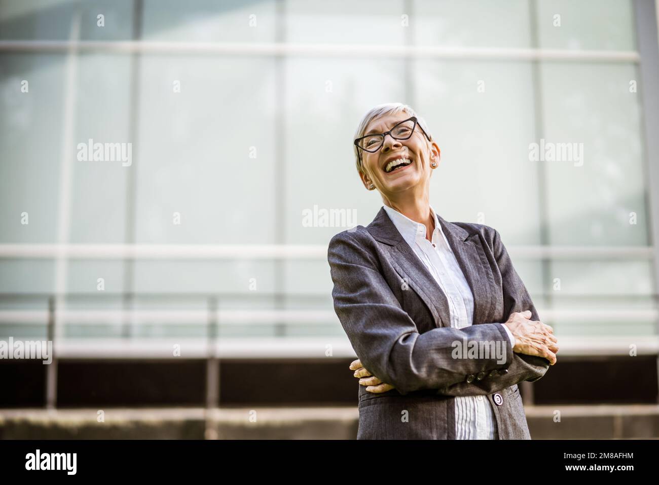 Ritratto all'aperto di una donna d'affari matura di successo di fronte alla costruzione dell'azienda. Foto Stock
