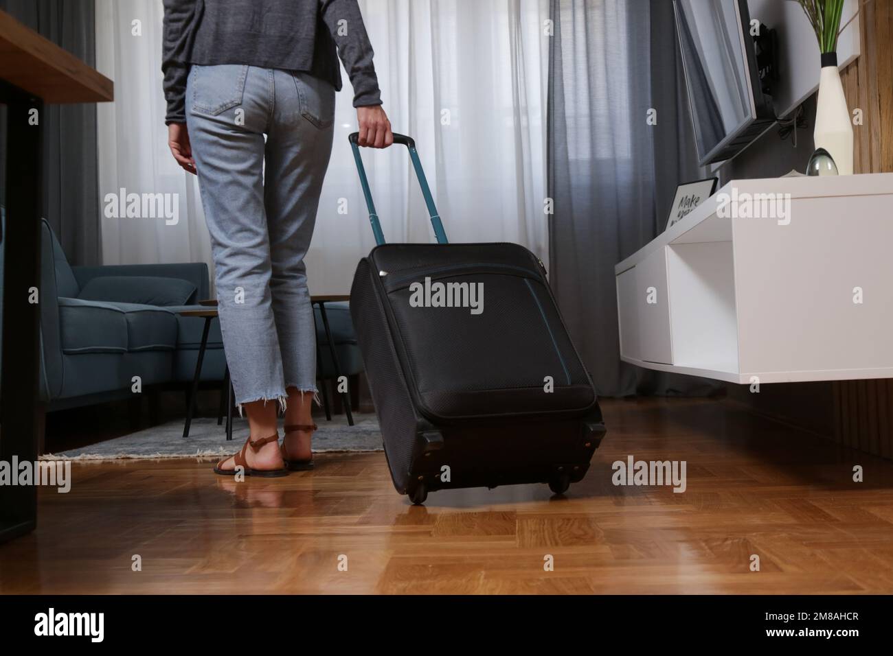 Giovane donna con i bagagli in hotel room Foto Stock