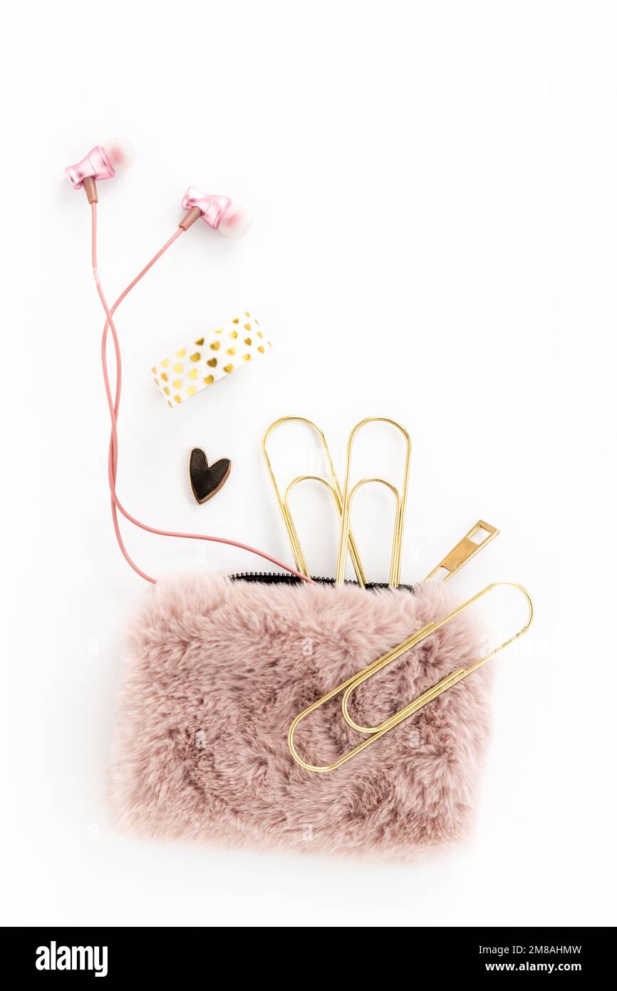 Oggetti femminili in oro e rosa, tra cui articoli da cancelleria, auricolari, borsetta e cuore Foto Stock