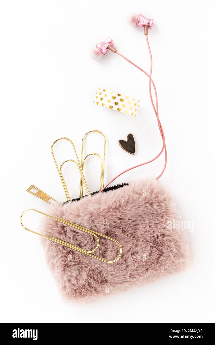 Oggetti femminili in oro e rosa, tra cui articoli da cancelleria, auricolari, borsetta e cuore Foto Stock