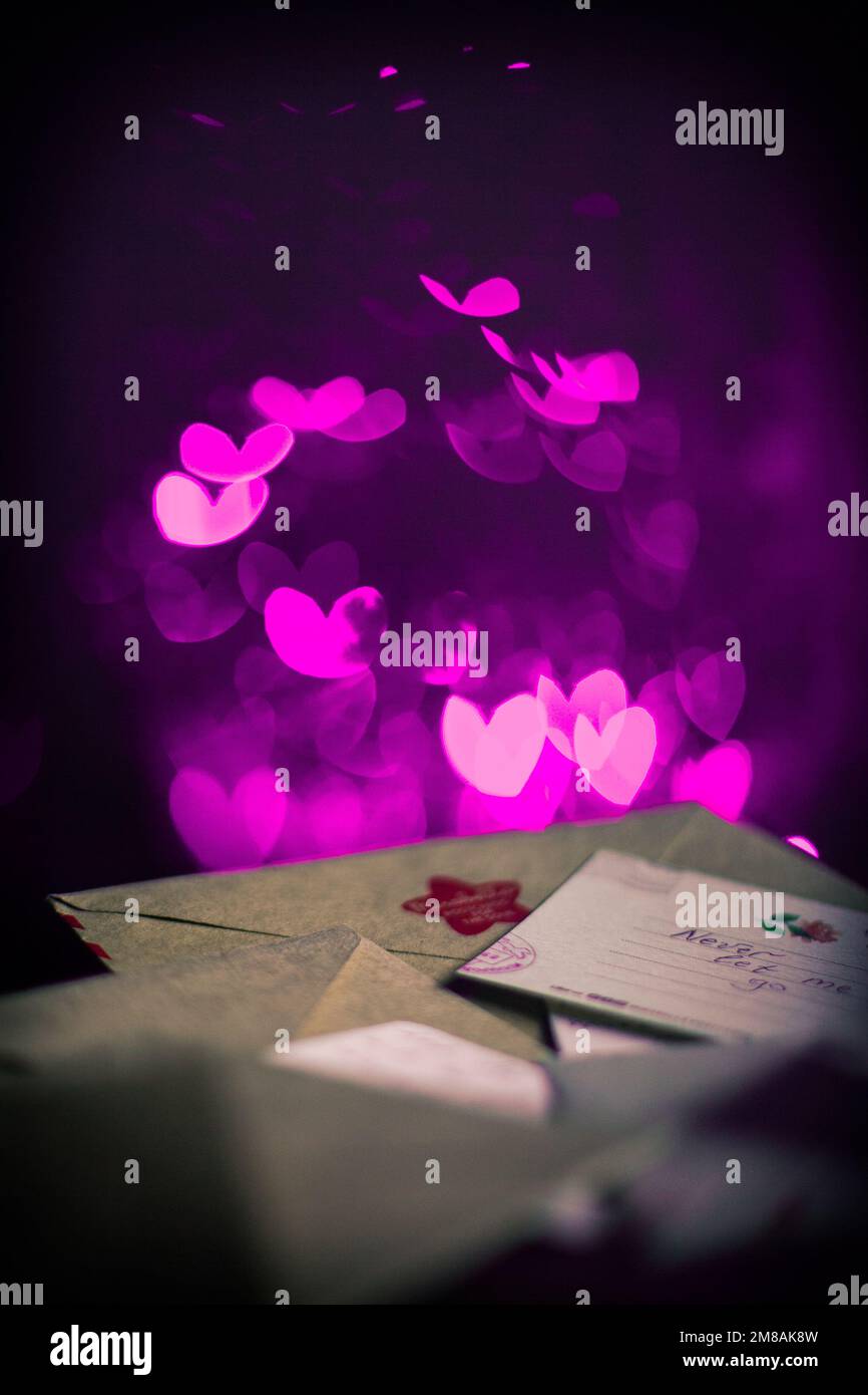 Lettere di San Valentino, carte, cuori di viola incandescente nel buio Foto Stock