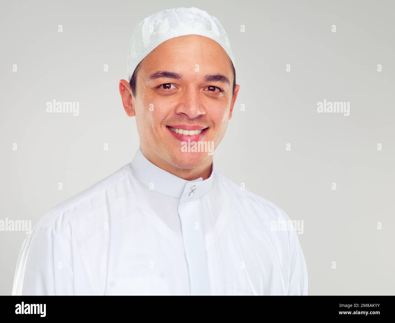 Ritratto, musulmano e religione con un uomo islamico in studio su uno sfondo grigio per fede, fede in dio o devozione. EID, culto e ramadan con un Foto Stock