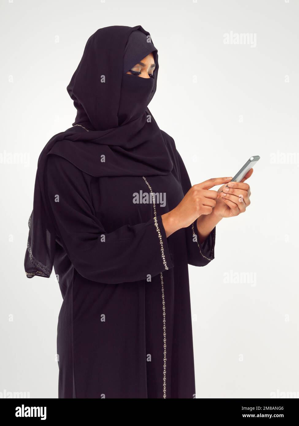 Musulmani, telefono e social media con una donna islamica in studio su uno sfondo grigio per la comunicazione o il networking. Contatto, internet e islam con Foto Stock
