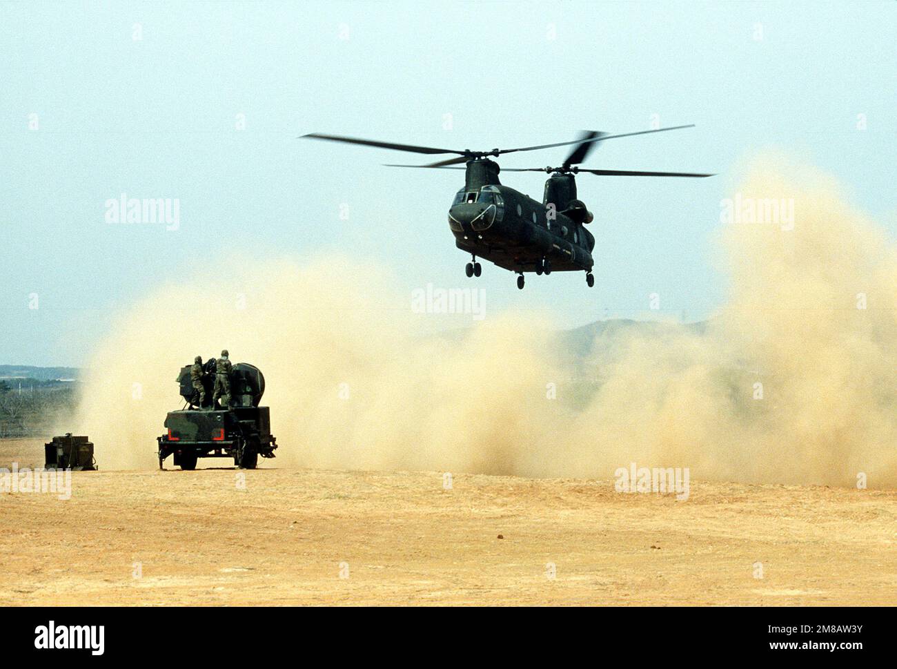 Un elicottero CH-47 Chinook solleva una nuvola di polvere mentre si avvicina per raccogliere un pezzo di attrezzatura sul campo durante l'esercizio Team Spirit '89. Soggetto operativo/Serie: TEAM SPIRIT '89 Paese: Corea del Sud Foto Stock