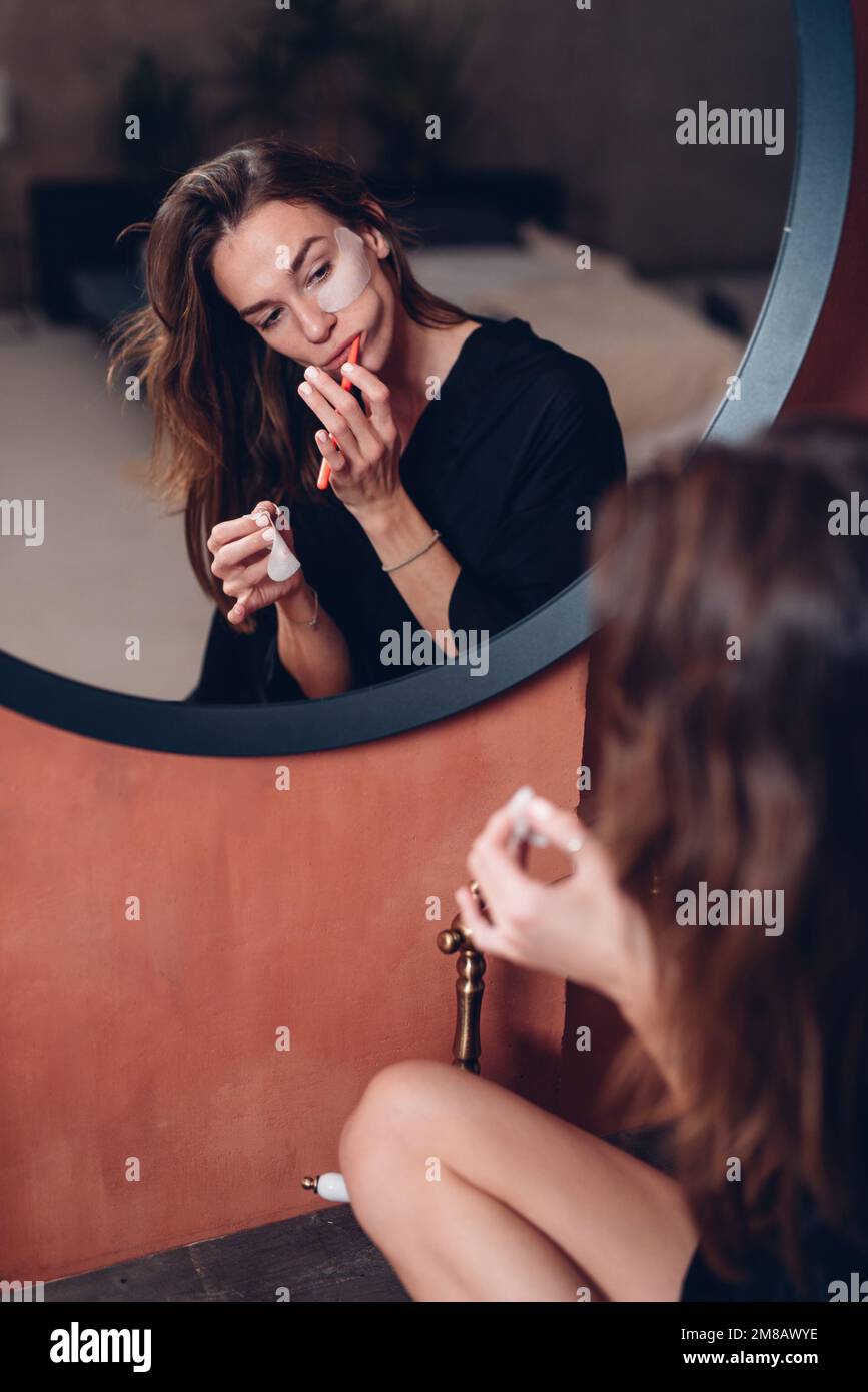 La giovane donna mette delle macchie mentre le sfiora i denti Foto Stock