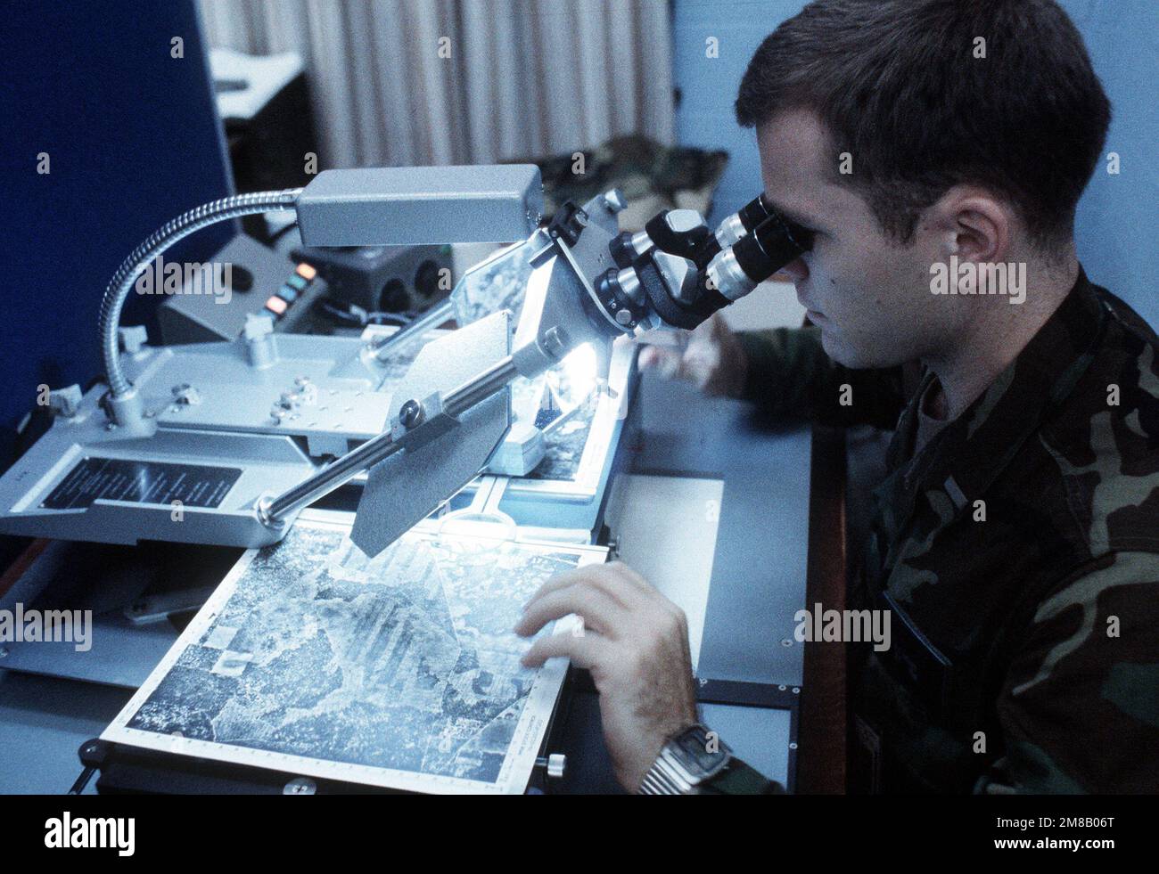 L'apparecchiatura del sistema di posizionamento FOTOGRAMMETRICO analitico viene utilizzata da 2nd LT. Paul D. Kuernes per esaminare una mappa aerea durante Jaguar Bite '89, un esercizio congiunto dell'esercito e dell'aeronautica condotto dagli Stati Uniti Comando operazioni speciali. Oggetto/Serie: JAGUAR BITE '89 base: Fort Campbell Stato: Kentucky (KY) Paese: Stati Uniti d'America (USA) Foto Stock