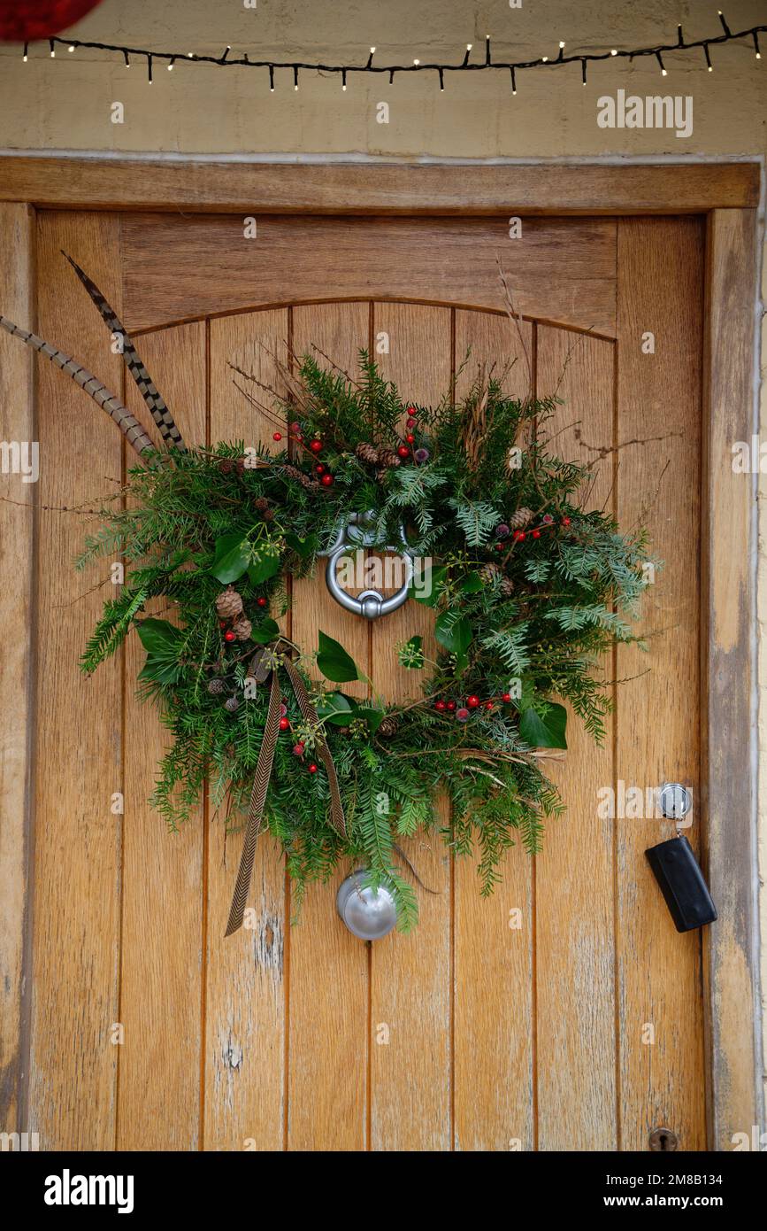Una corona di Natale esposta su una porta di legno. Foto Stock