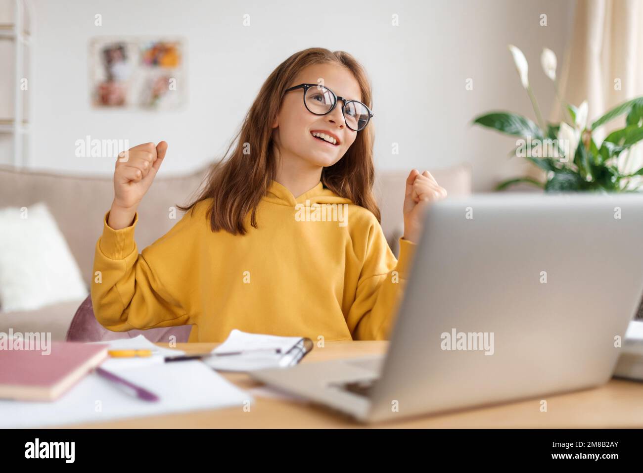 Emotivo ispirato ragazza trovato soluzione, finito il suo lavoro, superato esame, ottenuto eccellente marchio, sentirsi felice con il successo. Kid ama imparare online, studiare a casa con il laptop, Internet e tutor Foto Stock