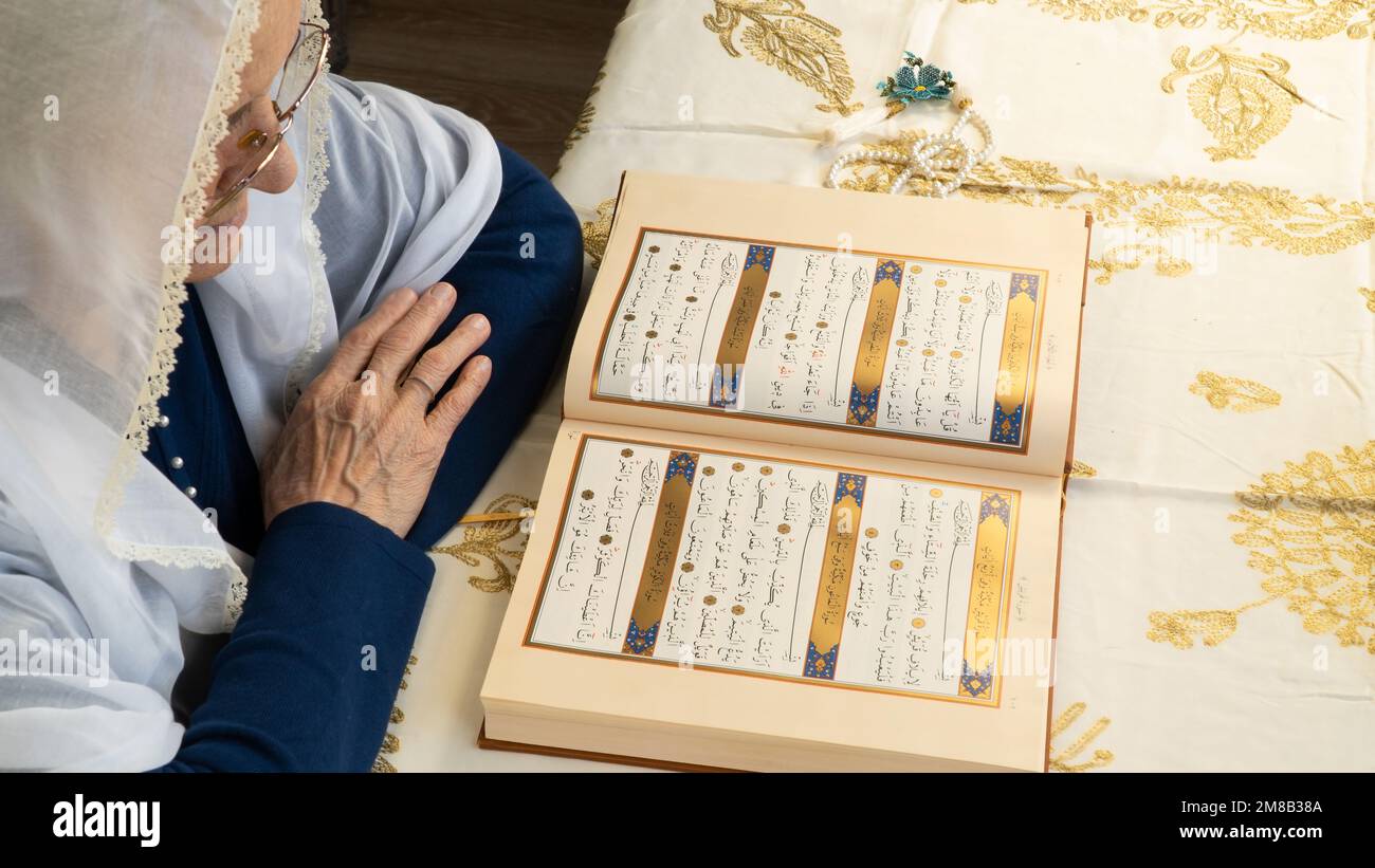Il Ramadan 2023 è tra marzo 23 e aprile 21. Vecchia donna che legge il Santo Corano nel Ramadan. Benvenuti Ramadan. 13 gennaio 2023 - Istanbul, Turchia. Foto Stock