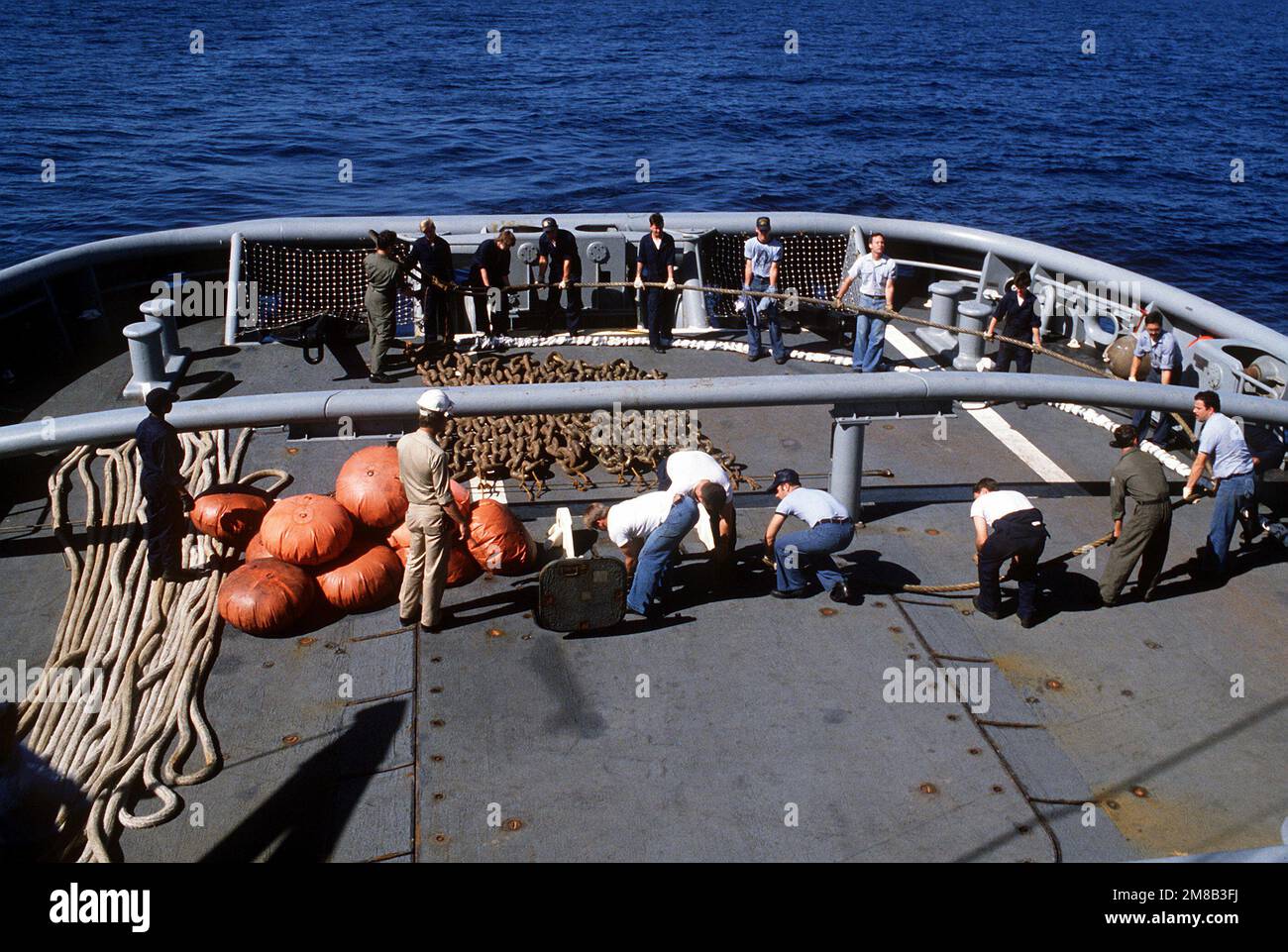 I membri dell'equipaggio fingono un cavo di traino sul ponte della nave di salvataggio USS GARS (ARS-51) durante le operazioni di salvataggio per liberare il cacciatorpediniere USS SPRUANCE (DD-963). Lo SPRUANCE si è aggirato su Andros Island, Bahamas, 25 gennaio 1989. Paese: Oceano Atlantico (AOC) Foto Stock