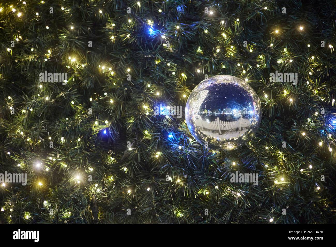 Garland con grande decorazione palla sull'albero di Natale. Foto Stock