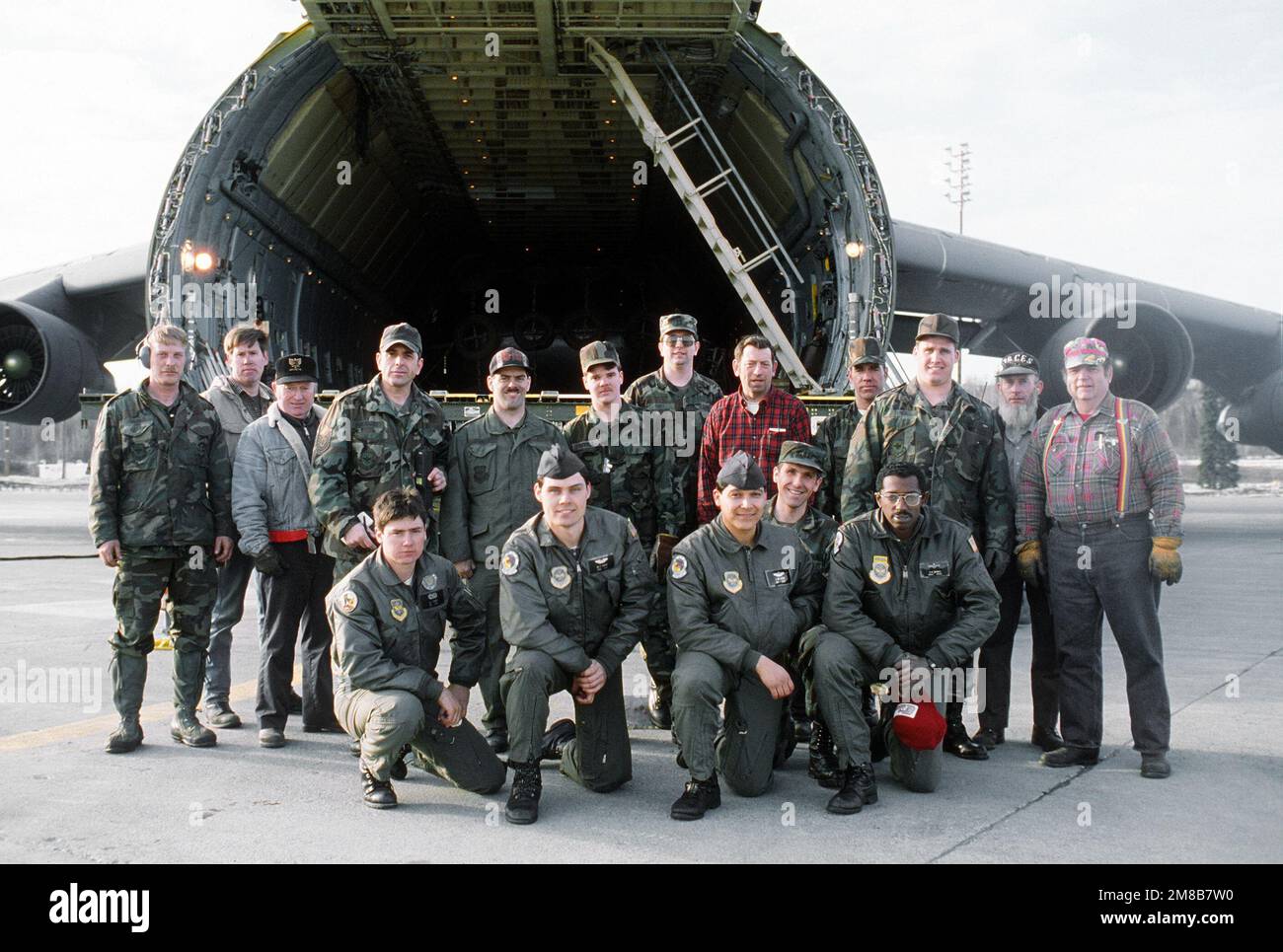 Gli uomini che hanno scaricato un aereo militare 3rd Airlift Squadron (3rd MAS) C-5B Galaxy si riuniscono di fronte al velivolo dopo il loro lavoro è fatto. Quattro membri del MAS 3rd si inginocchiano in prima fila; cinque civili e otto membri del 616th Aerial Port Squadron sono dietro di loro. Il velivolo trasportava attrezzature che saranno utilizzate per la pulizia del petrolio versato dalla petroliera Exxon Valdez a Price William Sound. Base: Elmendorf Air Force base Stato: Alaska (AK) Paese: Stati Uniti d'America (USA) Foto Stock Gli uomini che hanno scaricato un aereo militare 3rd Airlift Squadron (3rd MAS) C-5B Galaxy si riuniscono di fronte al velivolo dopo il loro lavoro è fatto. Quattro membri del MAS 3rd si inginocchiano in prima fila; cinque civili e otto membri del 616th Aerial Port Squadron sono dietro di loro. Il velivolo trasportava attrezzature che saranno utilizzate per la pulizia del petrolio versato dalla petroliera Exxon Valdez a Price William Sound. Base: Elmendorf Air Force base Stato: Alaska (AK) Paese: Stati Uniti d'America (USA) Foto Stock