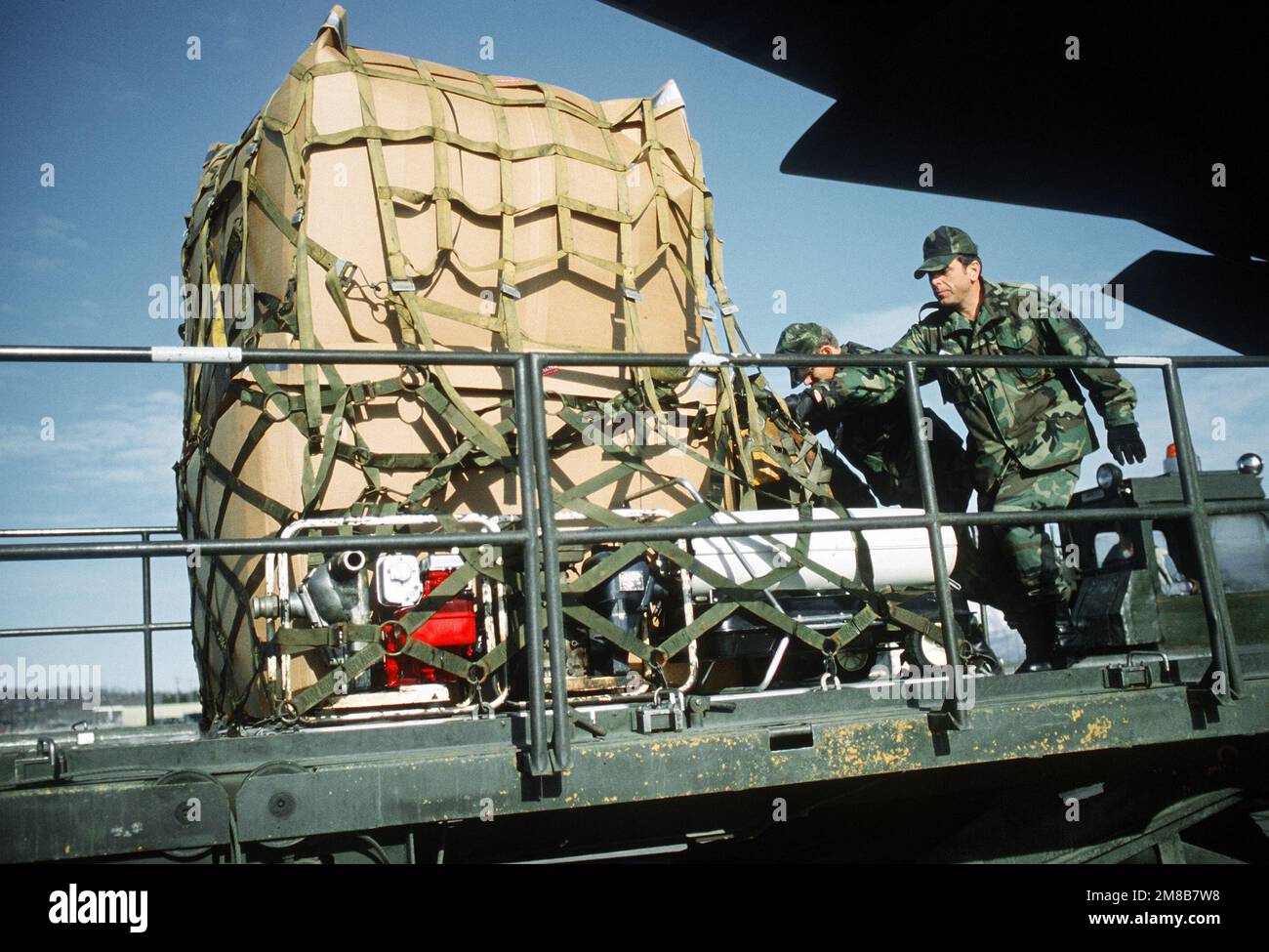 MASTER SENIOR SGT. George F. Burghardt dello Squadrone del Porto aereo 616th presta una mano ad un altro membro dello squadrone che spinge un pallet di attrezzatura su un caricatore K. L'attrezzatura, che sarà utilizzata per la pulizia del petrolio versato dalla petroliera Exxon Valdez in Price William Sound, è stata portata in Alaska a bordo di un aereo militare 3rd Airlift Squadron C-5B Galaxy. Base: Elmendorf Air Force base Stato: Alaska (AK) Paese: Stati Uniti d'America (USA) Foto Stock MASTER SENIOR SGT. George F. Burghardt dello Squadrone del Porto aereo 616th presta una mano ad un altro membro dello squadrone che spinge un pallet di attrezzatura su un caricatore K. L'attrezzatura, che sarà utilizzata per la pulizia del petrolio versato dalla petroliera Exxon Valdez in Price William Sound, è stata portata in Alaska a bordo di un aereo militare 3rd Airlift Squadron C-5B Galaxy. Base: Elmendorf Air Force base Stato: Alaska (AK) Paese: Stati Uniti d'America (USA) Foto Stock