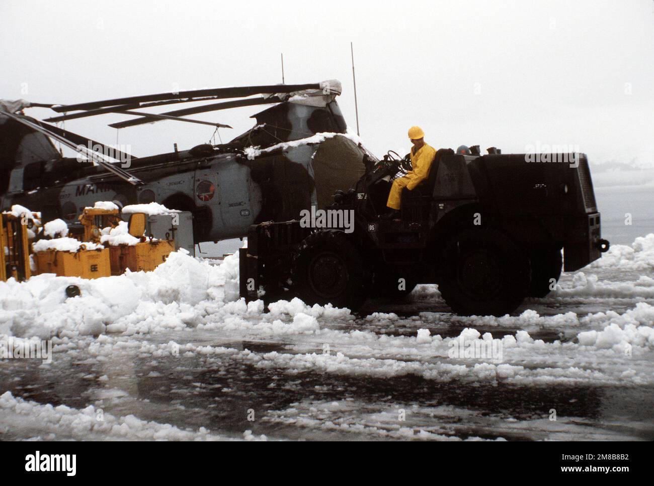Un carrello elevatore viene utilizzato per eliminare la neve da circa un elicottero CH-46E Sea Knight da Marine Medium Helicopter Squadron 166 (HMM-166) sul ponte di volo della nave di sbarco USS JUNEAU (LPD-10). Il JUNEAU sta fornendo sostegno al personale militare e civile che sta lavorando per ripulire il petrolio versato quando la petroliera EXXON VALDEZ si è arenata a Prince William Sound il 24 marzo. Base: Valdez Stato: Alaska (AK) Nazione: Stati Uniti d'America (USA) Foto Stock Un carrello elevatore viene utilizzato per eliminare la neve da circa un elicottero CH-46E Sea Knight da Marine Medium Helicopter Squadron 166 (HMM-166) sul ponte di volo della nave di sbarco USS JUNEAU (LPD-10). Il JUNEAU sta fornendo sostegno al personale militare e civile che sta lavorando per ripulire il petrolio versato quando la petroliera EXXON VALDEZ si è arenata a Prince William Sound il 24 marzo. Base: Valdez Stato: Alaska (AK) Nazione: Stati Uniti d'America (USA) Foto Stock