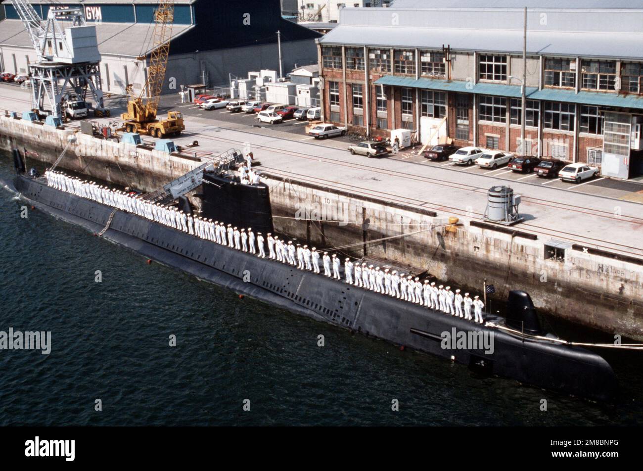 I membri dell'equipaggio imbustano le rotaie a bordo del sottomarino USS DARTER (SS 576) mentre la nave è ormeggiata presso un molo. Base: Attività della flotta, Sasebo Paese: Giappone (JPN) Foto Stock