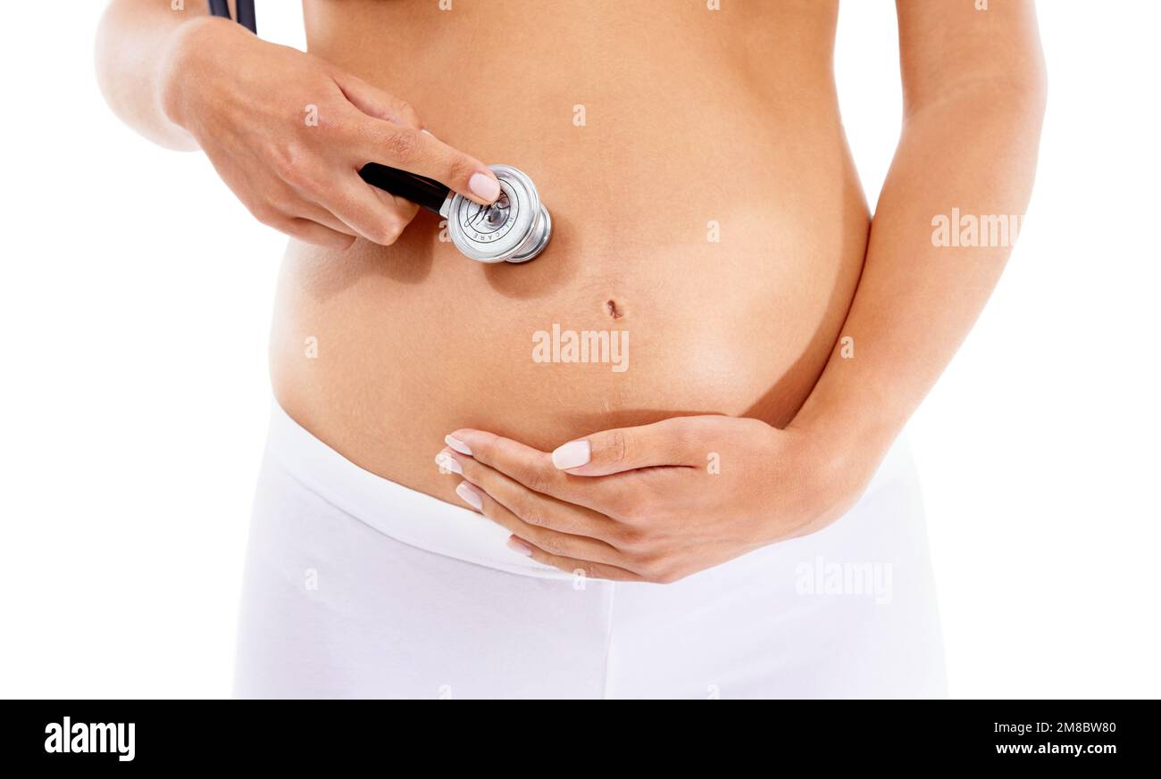 Assistenza sanitaria, gravidanza e stomaco di una donna con uno stetoscopio su sfondo bianco in studio. Bambino, addome e donna incinta che ascolta per la salute Foto Stock