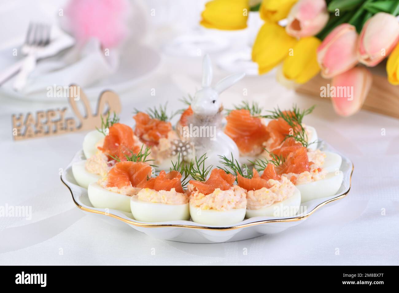 Antipasto di uova ripiene di salmone e tuorli con fette di salmone. Idea tavolo di Pasqua Foto Stock