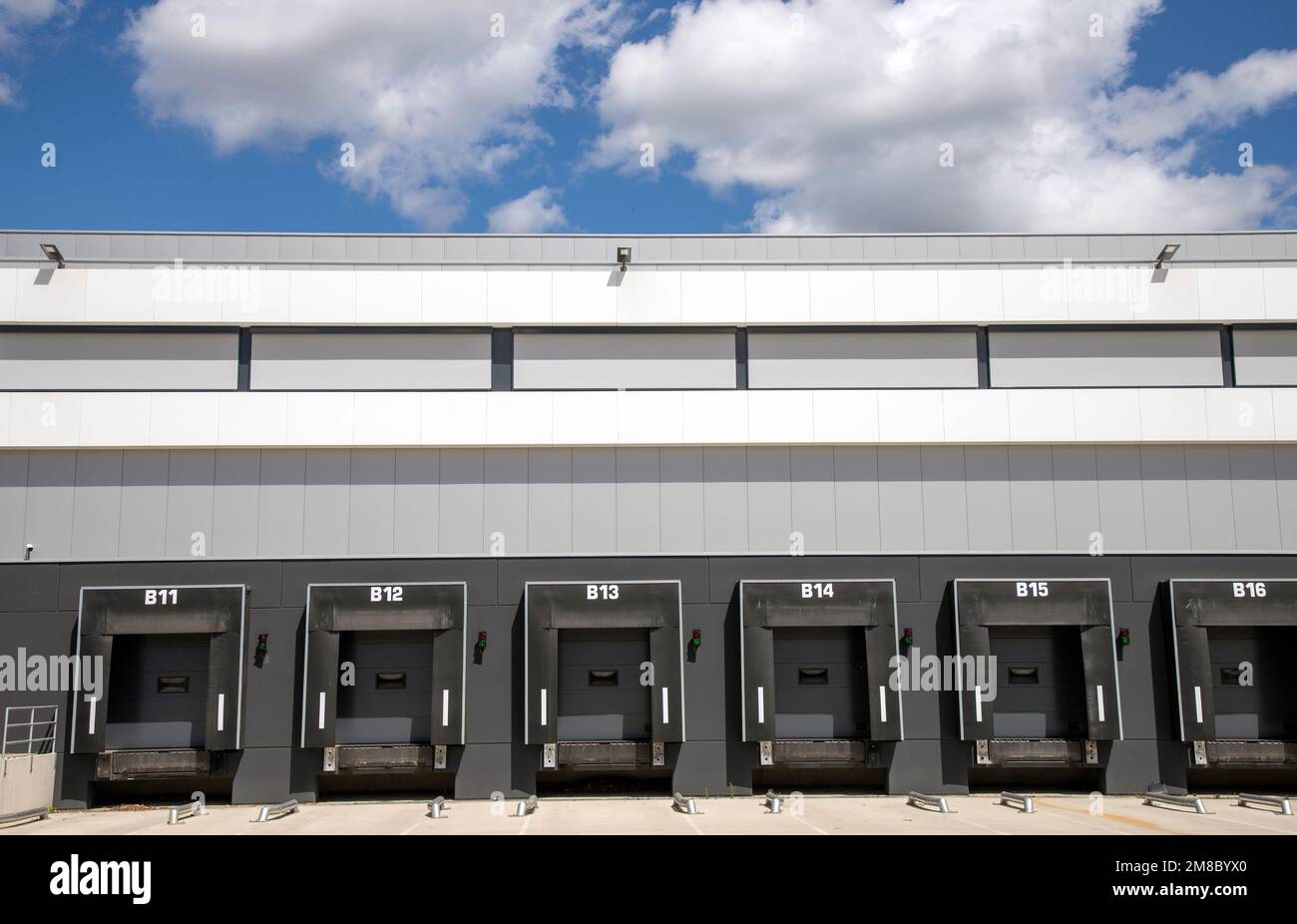 Una fila di banchine di carico con sportelli a saracinesca in un magazzino Foto Stock