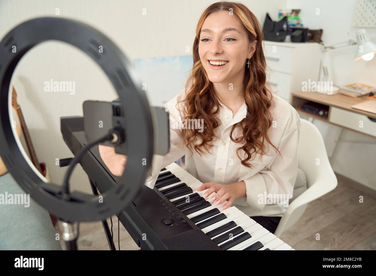 Allegro musicista che si prepara a registrare musica vlog per il pubblico online Foto Stock