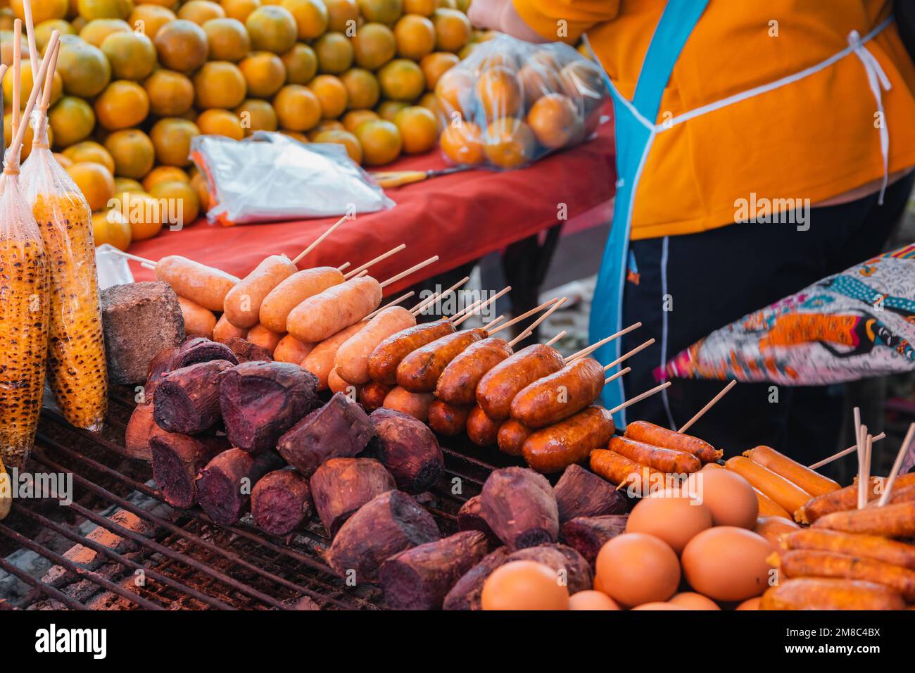 Salsicce in stile thailandese su un bastone e verdure grigliate da un venditore di cibo di strada e frutta al punto di vista Doi Kio Lom, Thailandia settentrionale. Foto Stock