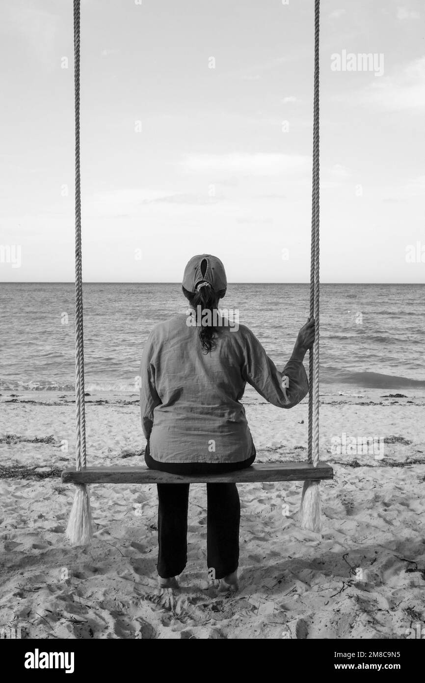 Donna che guarda all'oceano Foto Stock