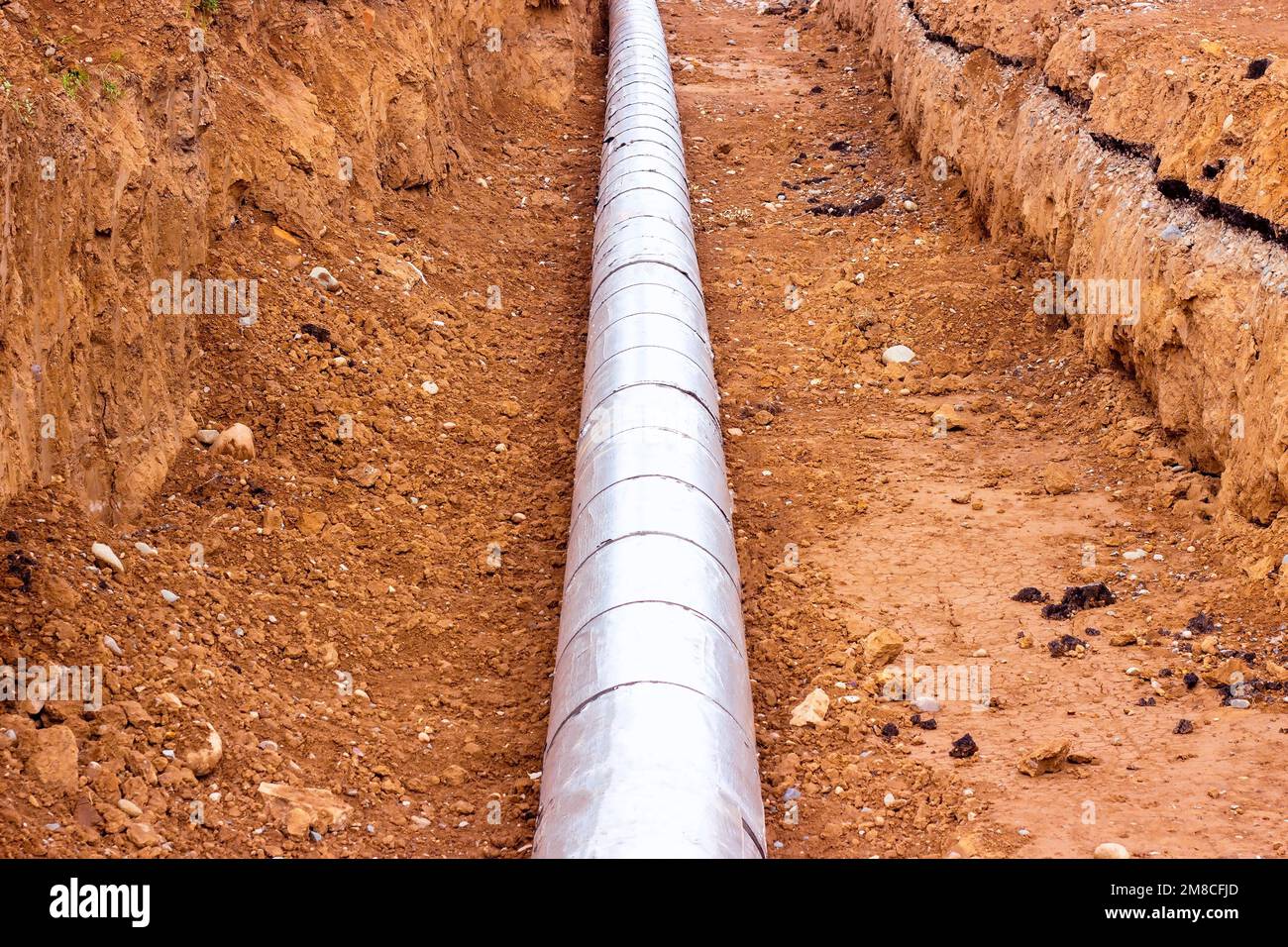 Installazione dell'unità di distribuzione della rete di riscaldamento e di alimentazione dell'acqua. Telaio per il collegamento di tubi nella trincea di terra. Foto Stock