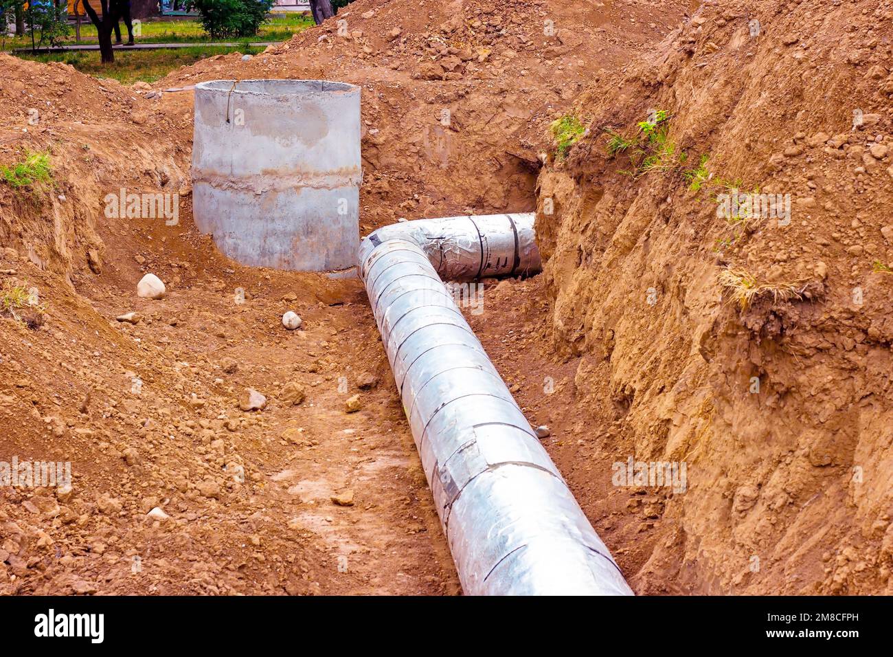Installazione dell'unità di distribuzione della rete di riscaldamento e di alimentazione dell'acqua. Telaio per il collegamento di tubi nella trincea di terra. Foto Stock