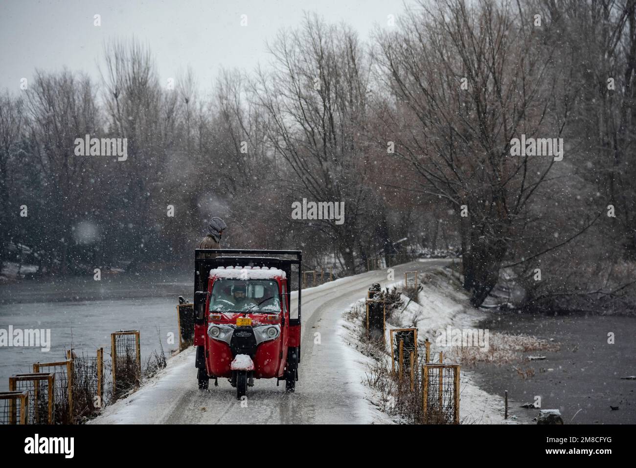 Un veicolo percorre una strada innevata tra le nevicate. Il Kashmir ha ricevuto nevicate fresche, con le cali più alte della valle che hanno ricevuto nevicate da moderate a pesanti e nevicate da leggere a moderate in pianura, causando una visibilità distruttiva. Questo ha influito sulle operazioni di volo insieme alla chiusura dell'autostrada nazionale Srinagar-Jammu. Foto Stock