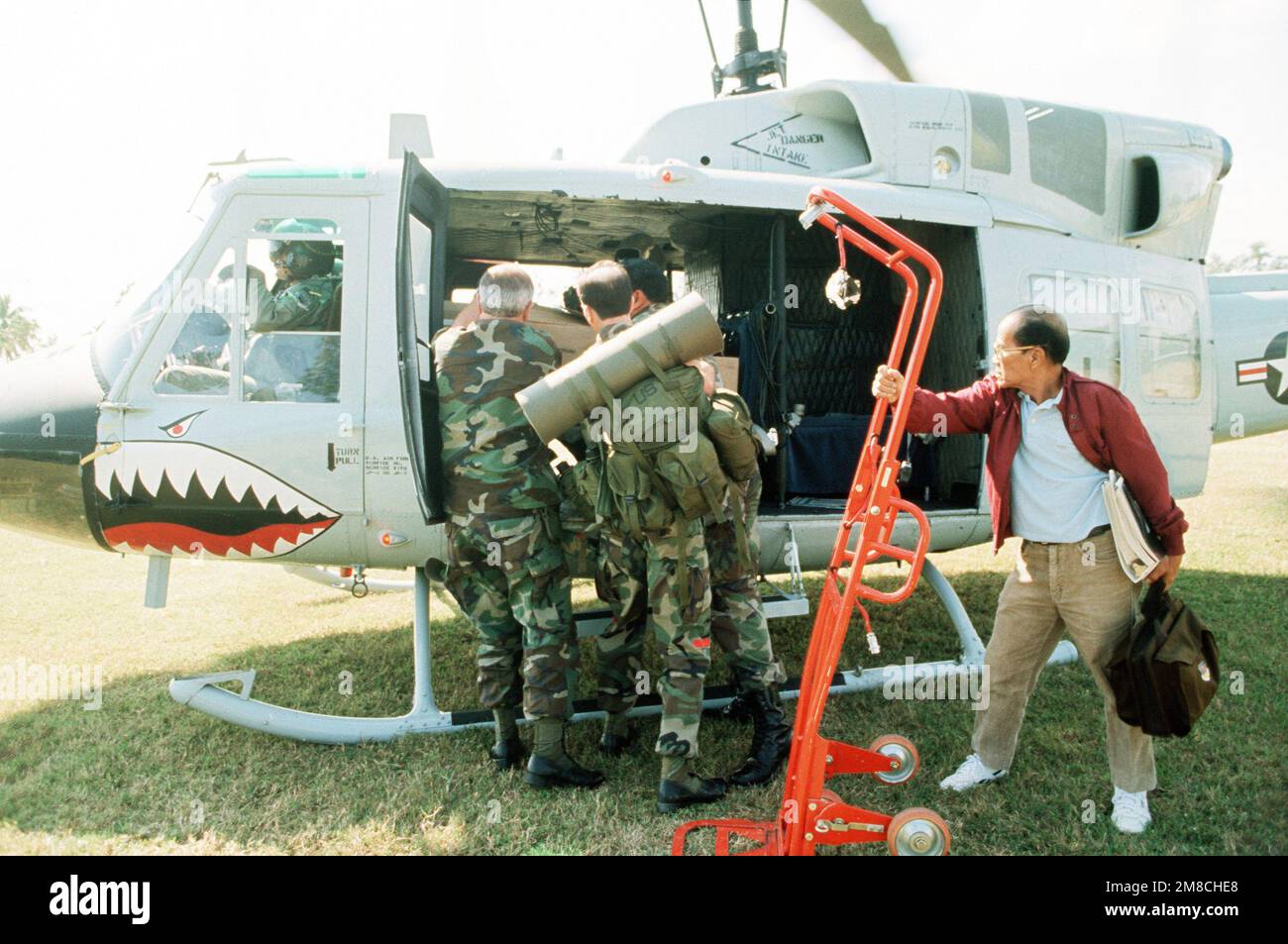 Il personale assegnato ad un impianto esterno scarica le forniture da un elicottero UH-1N Iroquois. L'installazione è stata chiusa come truppe fedeli alla battaglia del governo filippino per schiacciare un tentato colpo di stato da parte delle fazioni ribelli all'interno delle forze armate filippine. Paese: Filippine (PHL) Foto Stock