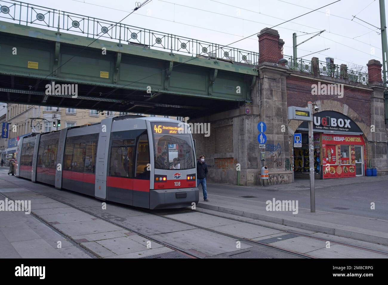 Un tram elettrico Siemens ELIN Ultra Low Floor passa sotto il ponte Währinger Straße Volksoper a Vienna, Austria. Dicembre 2022 Foto Stock