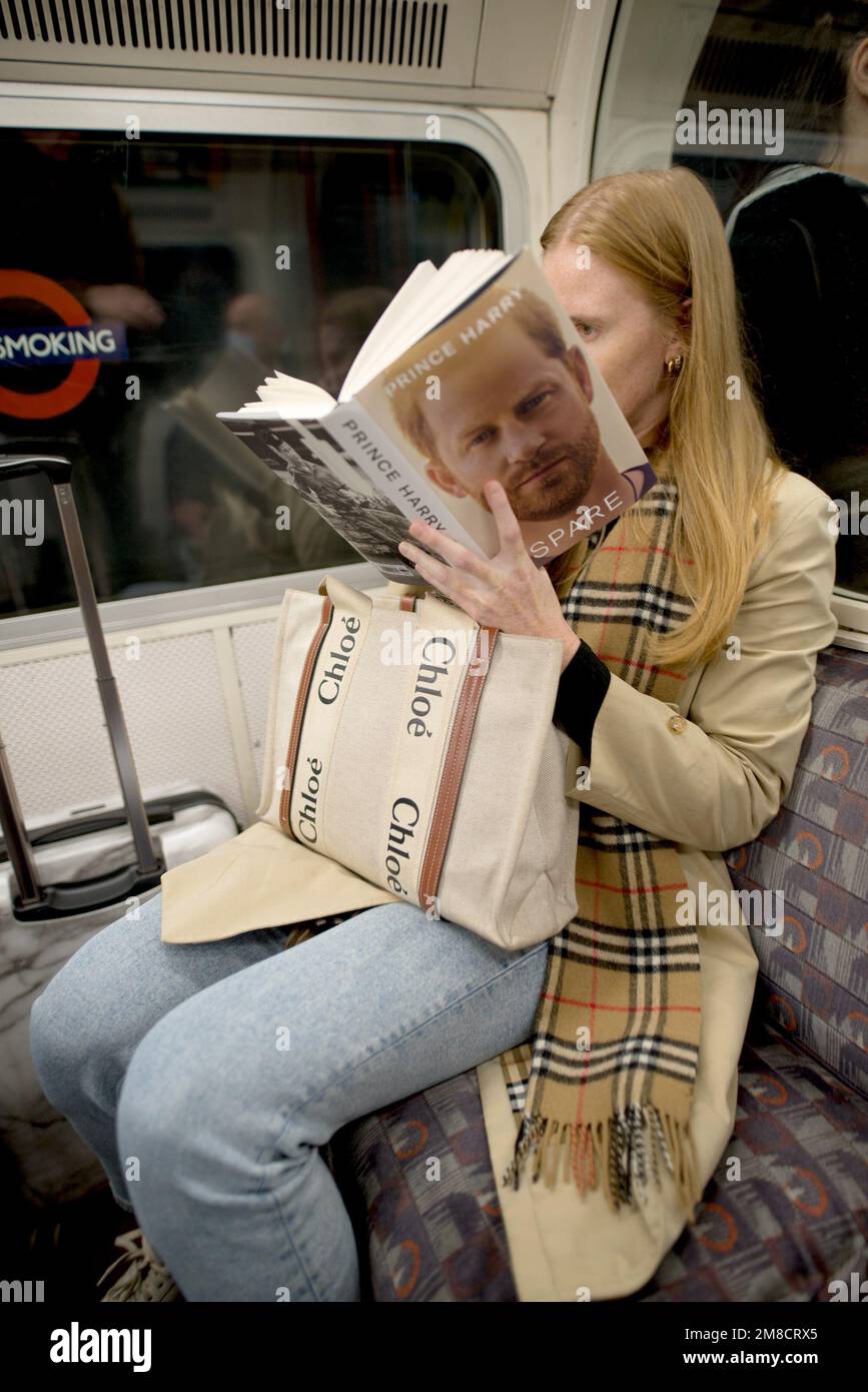 Londra, Regno Unito. 13th gennaio 2023. Una donna su un treno sotterraneo è avvincita nell'autobiografia 'Spare' del Principe Harry, e sembra essere circa a metà strada. Foto Stock