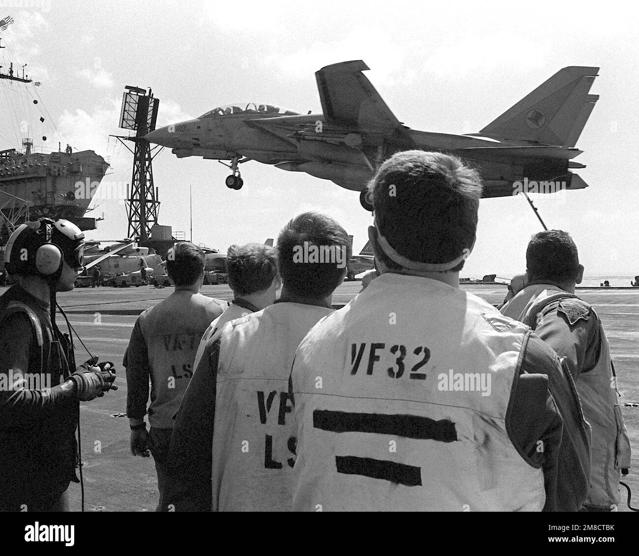 Gli ufficiali del segnale di atterraggio a bordo della portaerei USS JOHN F. KENNEDY (CV-67) osservano come un aereo del combattente Squadron (VF-14) F-14A Tomcat fa un atterraggio arrestato durante LA FLOTTA EX 1-90. Oggetto/Serie: FLOTTA EX 1-90 Paese: Oceano Atlantico (AOC) Foto Stock