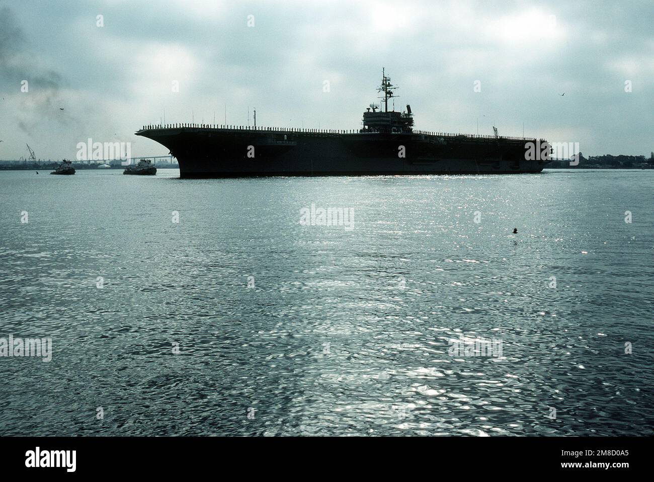 I membri dell'equipaggio man le rotaie mentre la portaerei USS COSTELLAZIONE (CV-64) entra in porto. Base: San Diego Stato: California (CA) Paese: Stati Uniti d'America (USA) Foto Stock