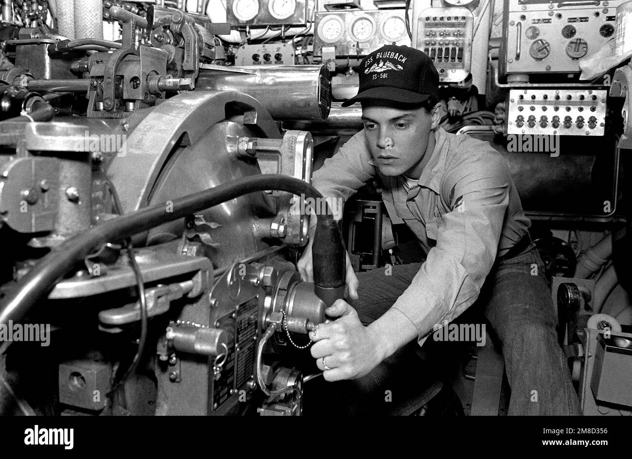 Un piccolo ufficiale stringe un vestito sulla porta della breccia di un tubo di siluro a bordo del sottomarino d'attacco USS BLUEBACK (SS-581). Il BLUEBACK, un sottomarino diesel-elettrico, è previsto per lo smantellamento dopo più di 30 anni di servizio attivo. Base: Naval Air Station, San Diego Stato: California (CA) Paese: Stati Uniti d'America (USA) Foto Stock
