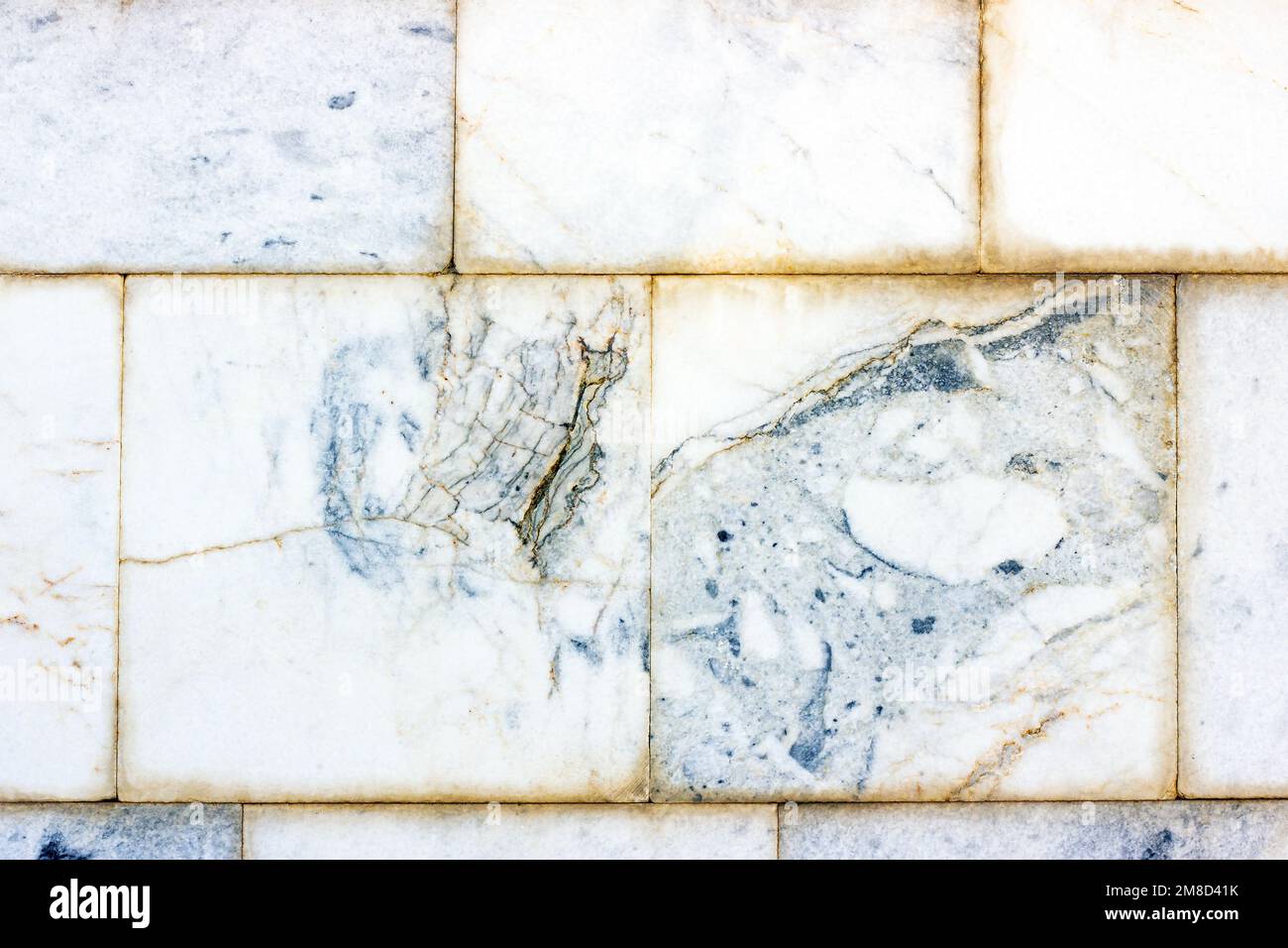Piastrelle in marmo vintage blu e grigio in ceramica sfondo testurizzato sul vecchio edificio pietra muro di mattoni in primo piano. Foto Stock