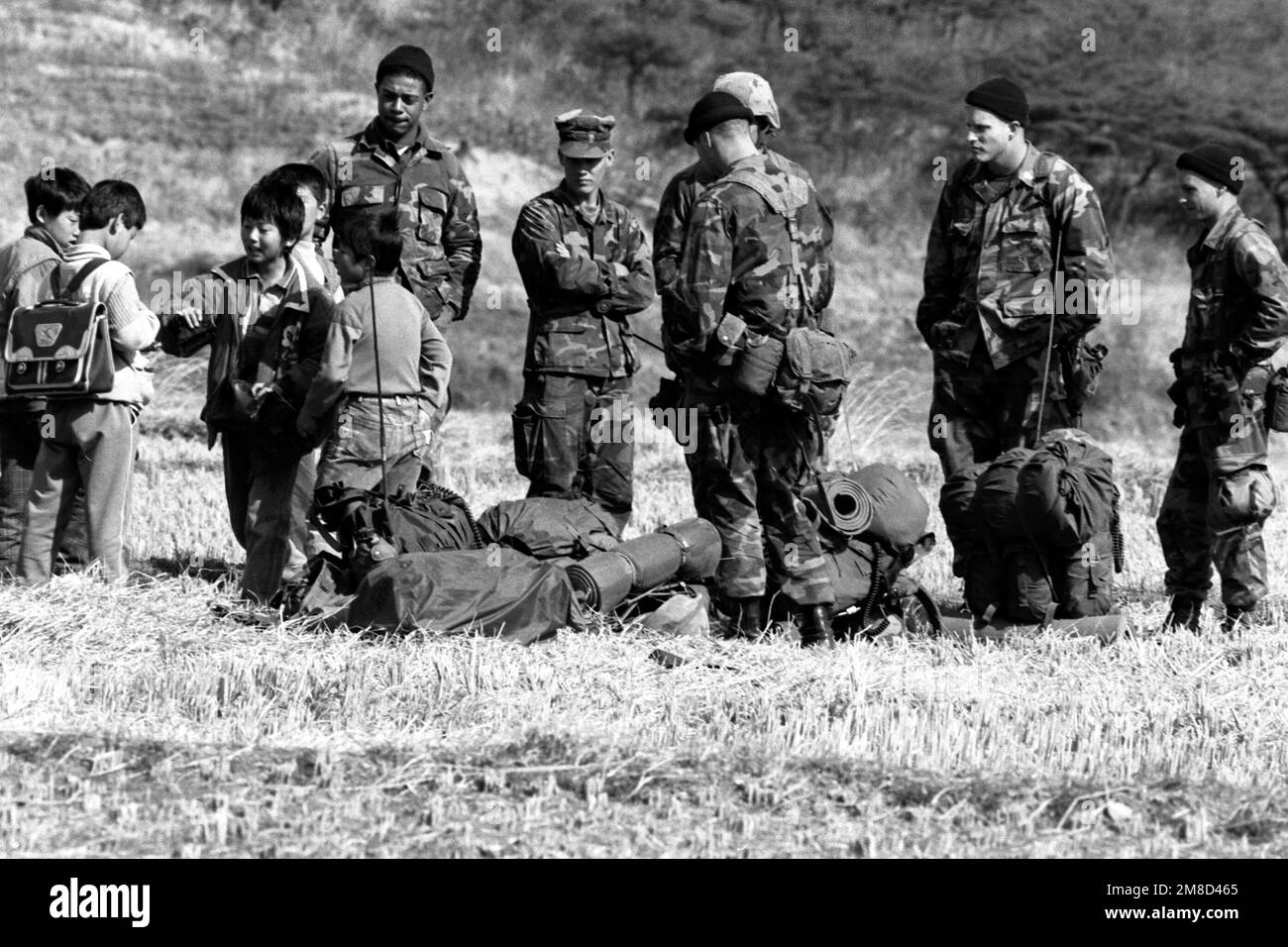 I bambini coreani esaminano i pacchetti di razioni di campo date loro da un gruppo di Marines durante l'esercitazione combinata di Spirit '90 della squadra sudcoreana/americana. Soggetto operativo/Serie: TEAM SPIRIT '90 Paese: Repubblica di Corea (KOR) Foto Stock