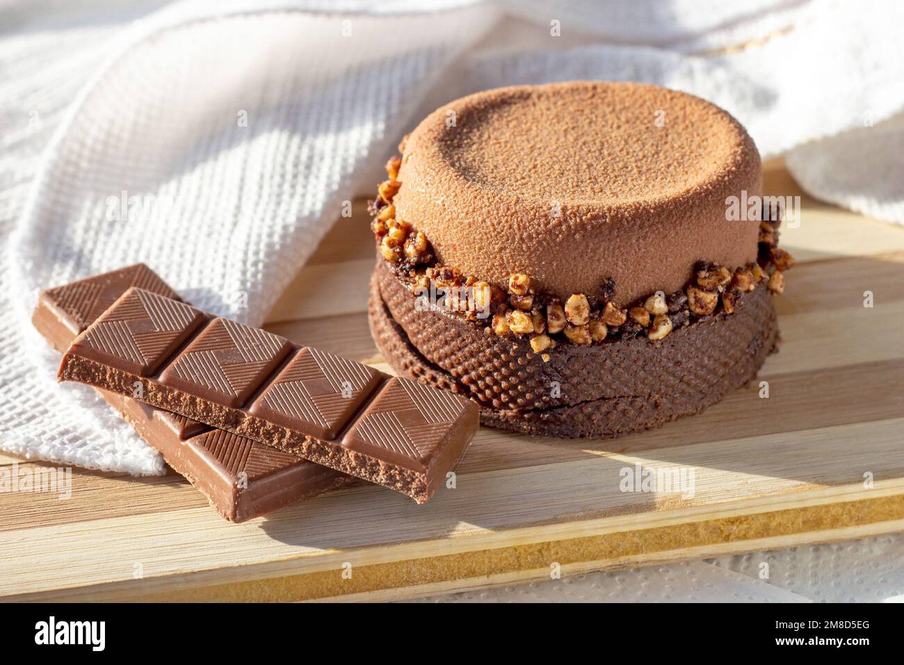 Crostata di cioccolato marrone con noci e caramello sullo sfondo del tavolo da cucina. Foto Stock