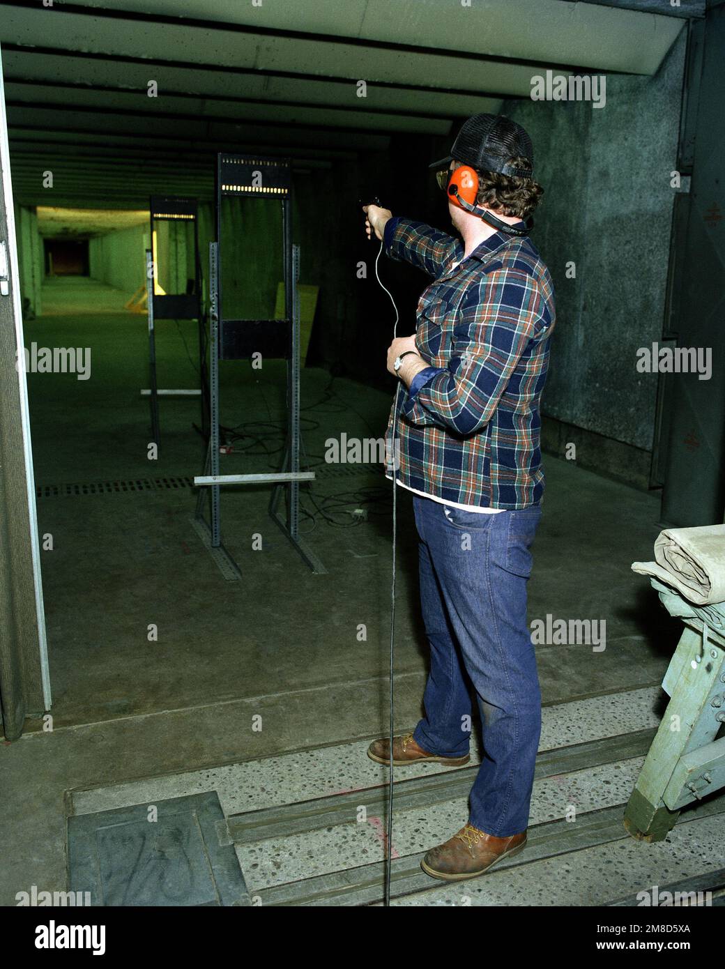 Un tecnico civile prova spara una pistola da M9 9 mm in un raggio interno all'arsenale. I cavi per un dispositivo di monitoraggio elettronico sono stati collegati alla pistola. Base: Rock Island Arsenal Stato: Illinois (il) Nazione: Stati Uniti d'America (USA) Foto Stock