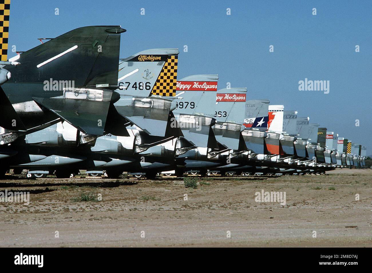 Le pinne di coda di una linea di velivoli Phantom II F-4D raffigurano marcature provenienti dalle unità della Guardia Nazionale aerea del Michigan, del North Dakota, del Texas, del Kansas e dell'Oregon. I fantocci sono parcheggiati in linea presso il Centro di rigenerazione della manutenzione aerospaziale, dove gli aerei immagazzinati che sono stati rimossi dal servizio vengono venduti per rottami, restituiti all'inventario o inviati ai musei. Base: Davis-Monthan Air Force base Stato: Arizona (AZ) Paese: Stati Uniti d'America (USA) Foto Stock