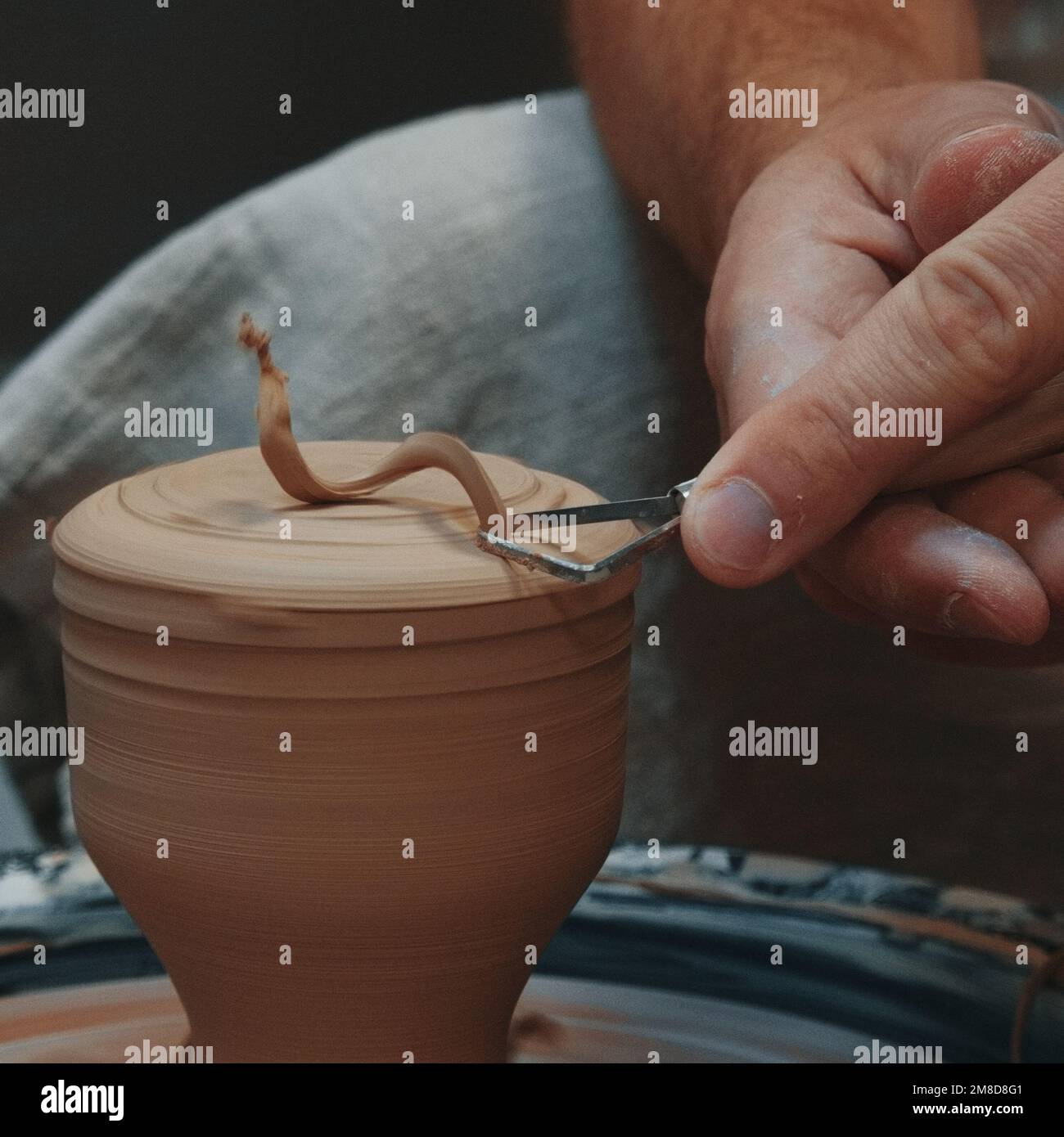 La persona di Potter scolpisce una pentola sulla ruota di un vasaio con le sue mani e l'attrezzo. Primo piano Foto Stock