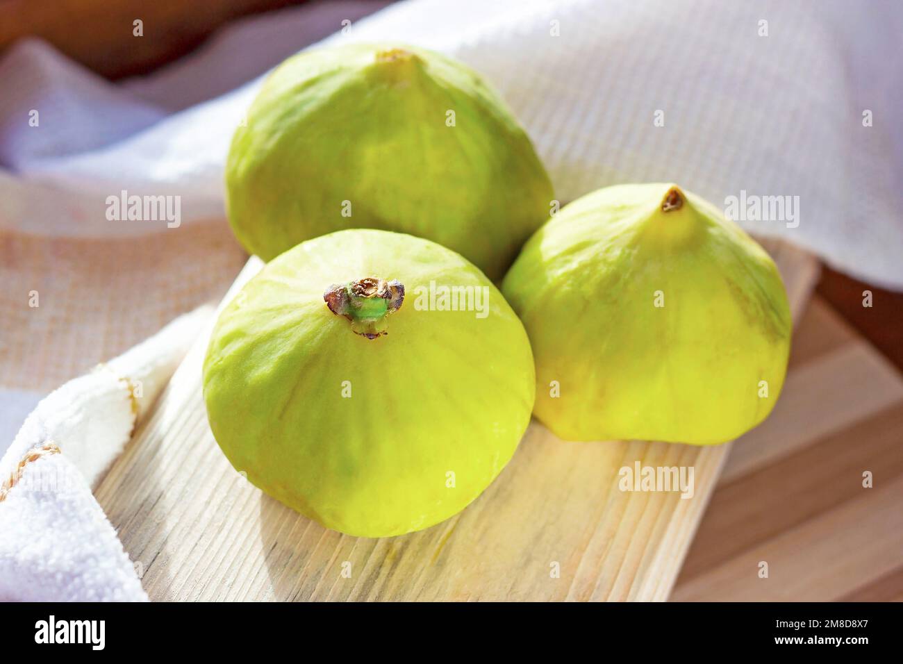 Frutta fresca di fico verde sulla tavola di legno in cucina primo piano durante la stagione estiva. Foto Stock
