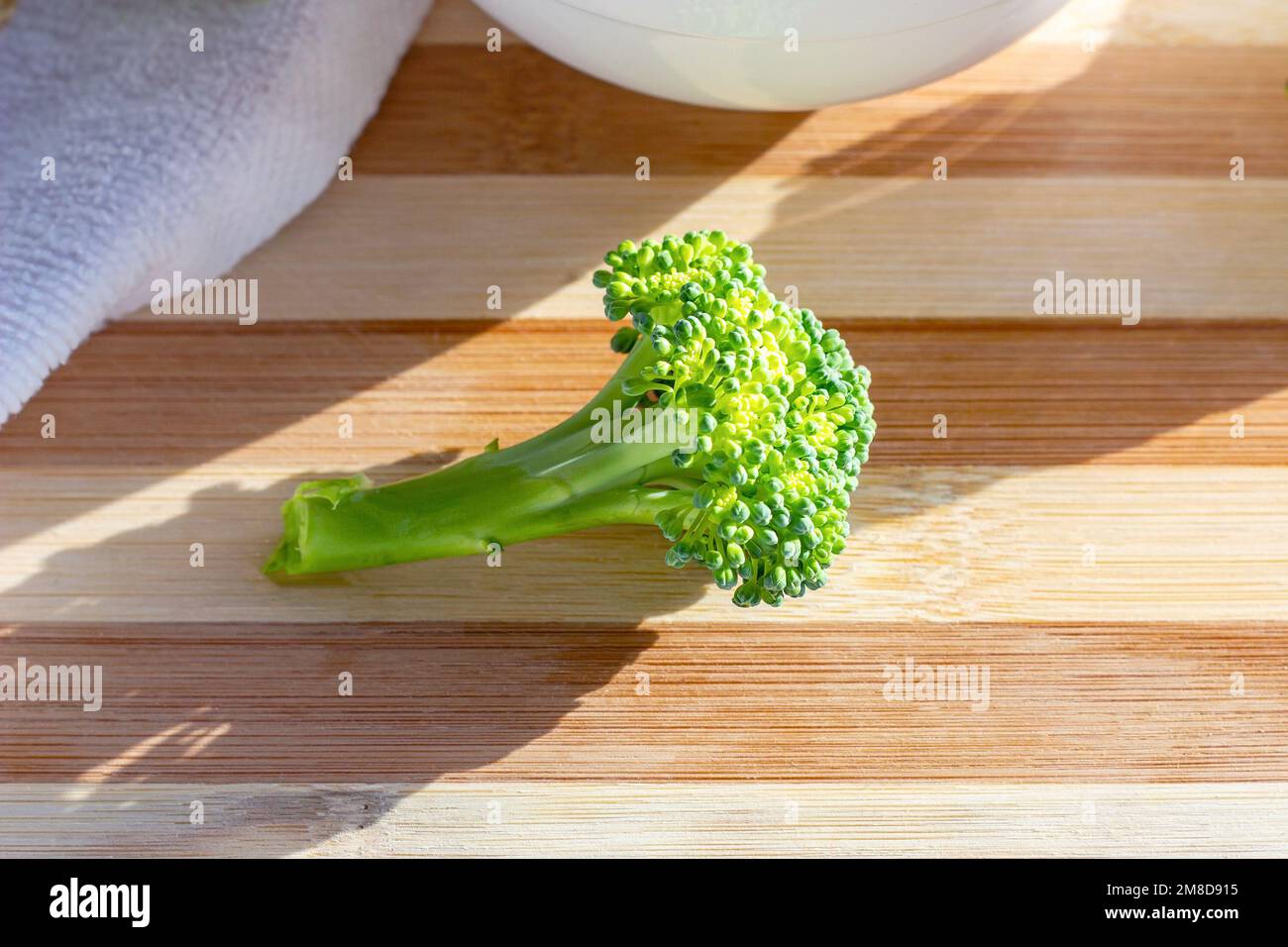 Broccoli grezzi biologici e luminosi sul tavolo in primo piano in cucina. Foto Stock