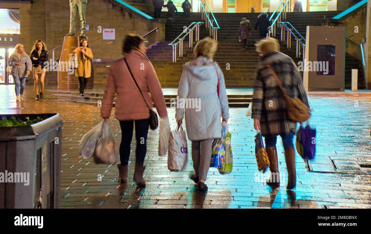 Glasgow, Scozia, Regno Unito 13th gennaio 2023. Il tempo del Regno Unito: Gli acquirenti sono i gradini della sala da concerto su bagnato e ventoso hanno visto fare shopping a tarda notte nel miglio di stile di Buchanan Street nel centro della città. Credit Gerard Ferry/Alamy Live News Foto Stock