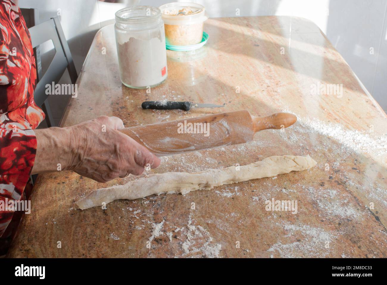 Irriconoscibile donna anziana mani con un matterello preparare l'impasto casadielles a casa. Gastronomia tradizionale Foto Stock