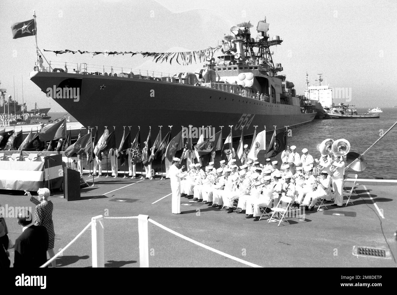 NEGLI STATI UNITI La banda della Marina gioca sul molo durante l'arrivo del cacciatorpediniere missilistico guidato sovietico, L'AMMIRAGLIO VINOGRADOV e la nave cisterna di supporto ARGUN, sfondo destro. L'ARGUN, il VINOGRADOV e una terza nave della flotta del Pacifico sovietico sono venuti a San Diego per una visita di buona volontà di cinque giorni. Base: San Diego Bay Stato: California (CA) Paese: Stati Uniti d'America (USA) Foto Stock