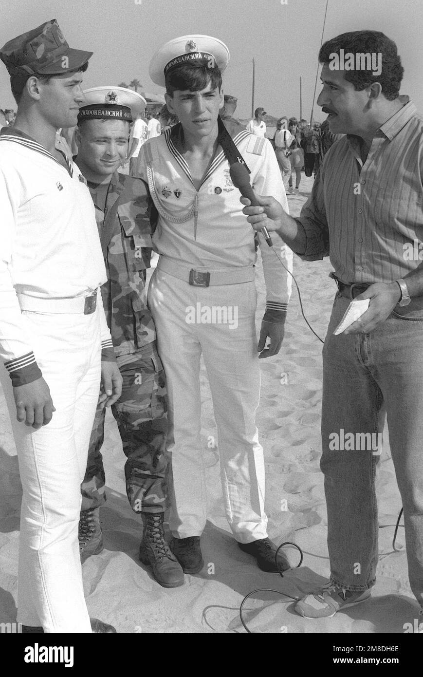 Un traduttore marino è affiancato da due marinai sovietici mentre sono intervistati da un reporter di una stazione televisiva locale. I sovietici assistono ad un barbecue e ad un rodeo che si tiene durante una visita di cinque giorni nell'area di San Diego da parte di tre navi della flotta del Pacifico sovietico. Base: Marine Corps base Camp Pendleton Stato: California (CA) Paese: Stati Uniti d'America (USA) Foto Stock