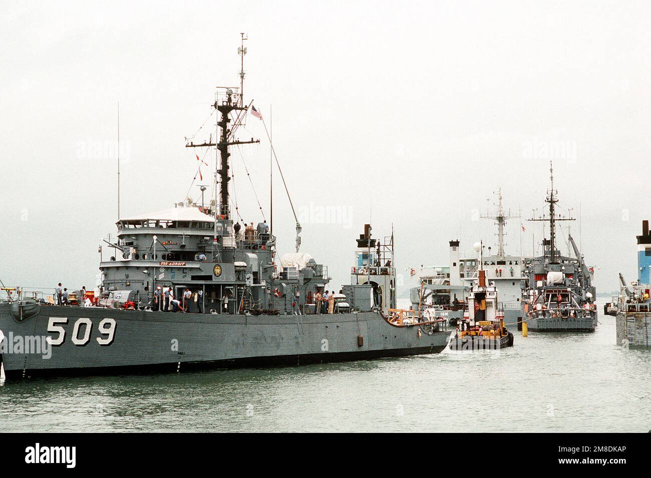 Una barca a rimorchiatore tira l'ORRIDO dell'oceano USS ADROIT (MSO-0509) sul ponte sommerso della nave pesante olandese Super SERVER 3. Il LEADER della USS (MSO-490) è sulla destra. Tre minatori oceanici e una nave di contromisure minerarie sono stati caricati a bordo del SUPER SERVITORE 3 per il trasporto al Golfo Persico, dove sosterranno le forze degli Stati Uniti inviate nella regione in risposta all'invasione dell'Iraq del Kuwait. Soggetto operativo/Serie: DESERT SHIELD/STORM base: Naval Air Station, Norfolk Stato: Virginia (VA) Paese: Stati Uniti d'America (USA) Foto Stock