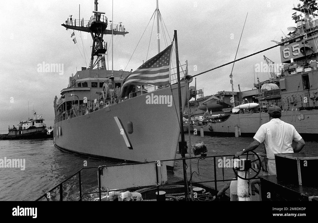 Un equipaggio a bordo di una barca da lavoro guarda come la nave di contromisura della miniera USS AVENGER (MCM-1) è posizionata accanto al minesweeper oceano USS ADROIT (MSO-509) sul ponte sommerso della nave pesante olandese Super SERVOR 3. Il SUPER SERVITORE 3 sta trasportando le navi, insieme ad altri minatori, nel Golfo Persico in risposta all'invasione del Kuwait da parte dell'Iraq. Subject Operation/Series: DESERT STORMDESERT Shield base: Naval Air Station, Norfolk Stato: Virginia (VA) Paese: Stati Uniti d'America (USA) Foto Stock